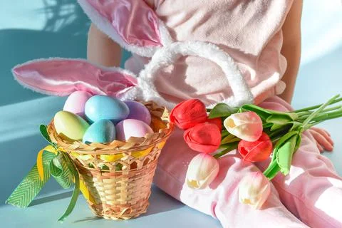 Easter painted eggs, Easter bunny ears and a bouquet of tulips lie on the chi Stock Photos
