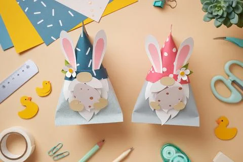 Easter paper craft gnomes with rabbit ears and eggs in their hands. DIY handm Stock Photos