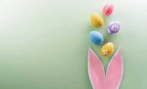 Easter party concept. Top view of easter bunny ears and colorful eggs on pa.. Illustrazione stock