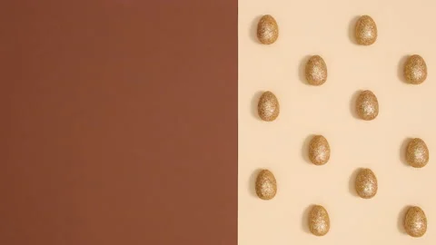 Easter pattern with golden glitter eggs appear on nude background. Stop motion Stock Footage 150284592