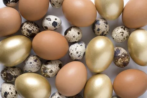 Easter pattern of golden, quail, chicken eggs. View from above. Flat lay. Stock Photos