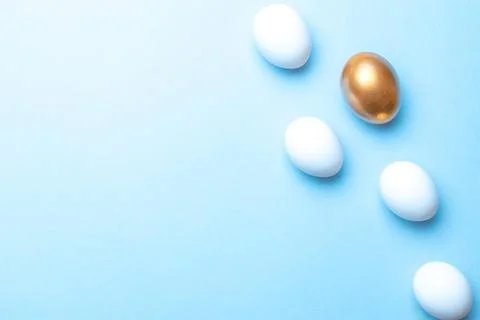 Easter pattern. Golden, white colour egg on pastel blue background in Happy 스톡 사진