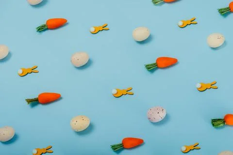 Easter pattern made of colored eggs, decorative carrots, and yellow bunny 写真素材