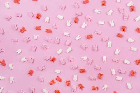 Easter pattern made of decoration with bunny ears sugar sprinkle top on pink Foto stock