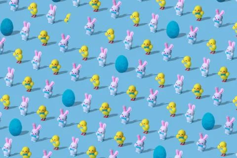 Easter pattern made of rabbits hares, chicken and egg woolen toys on blue Stock Photos