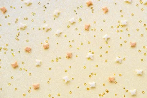 Easter pattern made of white and yellow butterflies and confetty on a yellow Stock Photos