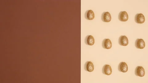 Easter pattern with moving golden glitter eggs on nude background. Stop motion Stock Footage 150284485