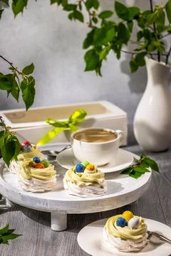 Easter pavlova nests with candy eggs and coffee Stock Photos