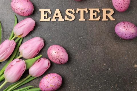 Easter. Pink Easter eggs and flowers tulips on a dark background. Happy easte Stock Photos
