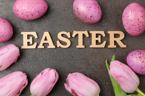 Easter. Pink Easter eggs and flowers tulips on a dark background. Happy easte Stock Photos