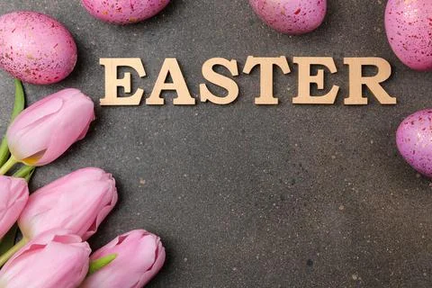 Easter. Pink Easter eggs and flowers tulips on a dark background. Happy easte Foto stock