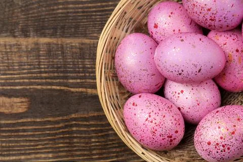 Easter. Pink easter eggs in basket on brown wooden table. Happy easter. holid Stock Photos