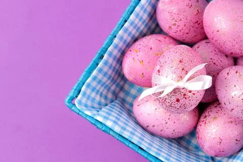 Easter. Pink Easter eggs in a basket on a trendy lilac background. Happy east Stock Photos