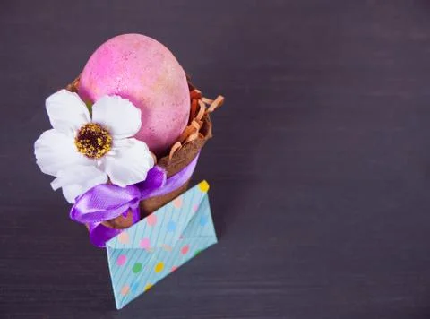 Easter pink egg in a pot with envelope on the black background Stock Photos