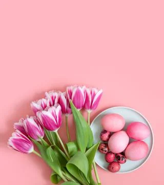 Easter pink table setting with eggs and a bouquet of spring flowers of tulips Stock Photos