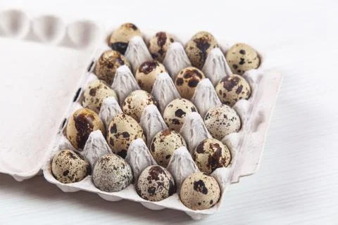 Easter quail eggs in container on bright background 스톡 사진