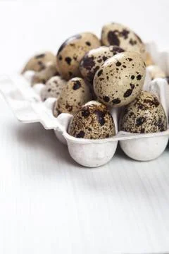 Easter quail eggs in container on bright background Foto stock