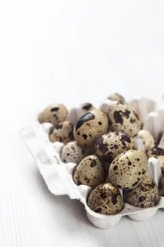Easter quail eggs in container on bright background Foto stock