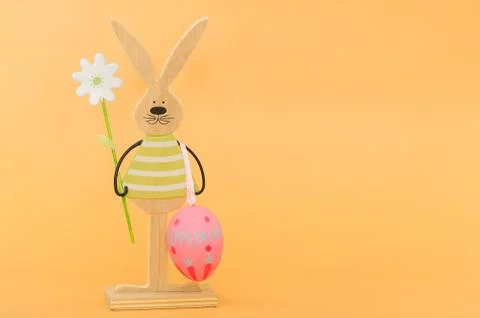 Easter rabbit and egg, orange background, with copy space Stock Photos