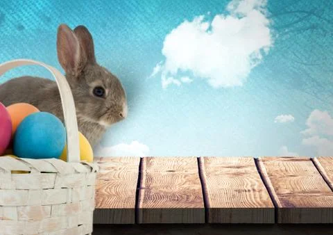 Easter rabbit with eggs basket in front of blue sky Stock Fotos