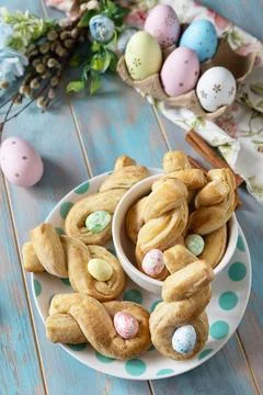 Easter rabbit-shaped buns puff pastry with  cinnamon on a wooden blue table.. Stock Photos