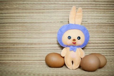 Easter rabbittoy with eggs in the straw background Fotos de archivo