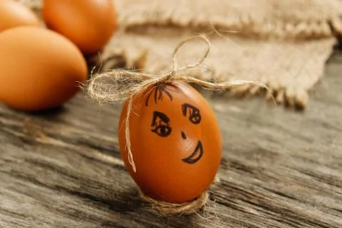 Easter. Raw eggs in the bow on sackcloth on wooden table Stock Photos