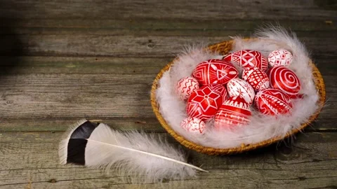 Easter red eggs with folk pattern inside basket. Man put on brass candlestick Stock-Footage 127886603