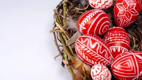 Easter red eggs with folk pattern into bird nest. Hand add eggs to nest. Stock-Footage 127887883