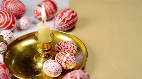 Easter red eggs with folk white pattern lay around of brass candlestick Stock-Footage 127888656