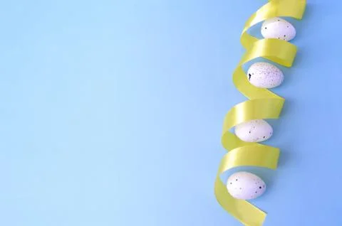 Easter right side border, white quail eggs with yellow ribbon on pastel blue Stock Photos