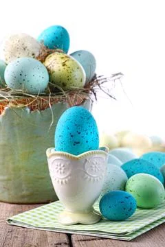 Easter scene with turquoise speckled egg in cup Stock Photos