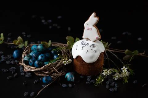 Easter set. Quail eggs and a easter cake with candy in the shape of a rabbit. Stock Photos