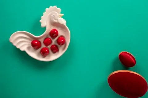 Easter small and big red eggs with a decorative rooster plate Stock Photos