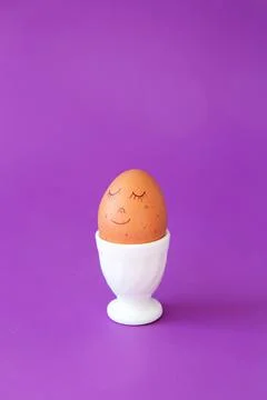Easter smiling egg in egg cup. Easter holiday concept with cute handmade egg. Stock Photos