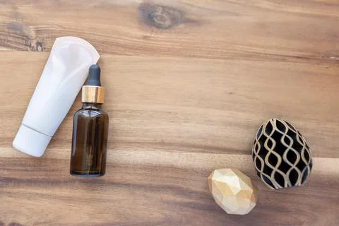 Easter spa. Hand and face cream and oil in glass bottle on wooden background Stock Illustration