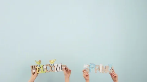 Easter spring decor. Children's hands are holding and shaking wooden signs with Stock Footage 101353192