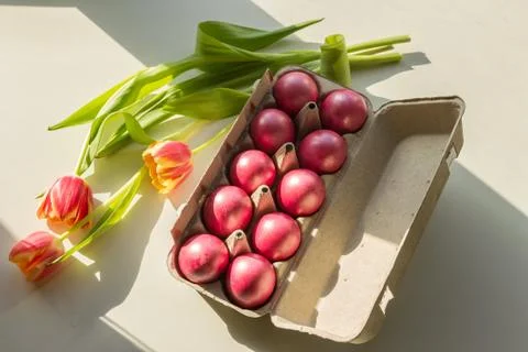 Easter spring scene, painted eggs in a box, tulips flowers, top view 库存照片
