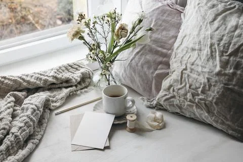 Easter spring still life. Cup of coffee and floral bouquet on window sill. White Stock Photos