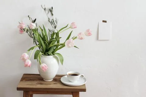Easter, spring still life scene. Cup of coffee and floral bouquet in ceramic 写真素材