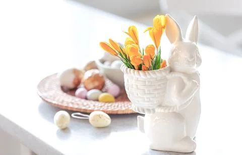 Easter still life with a ceramic hare, eggs and flowers. Stock Photos