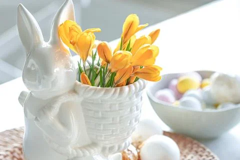 Easter still life with a ceramic hare, eggs and flowers. Stock Photos