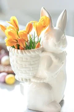 Easter still life with a ceramic hare, eggs and flowers. Stock Photos