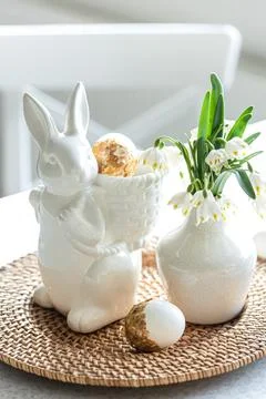 Easter still life with a ceramic hare, eggs and flowers. Stock Photos