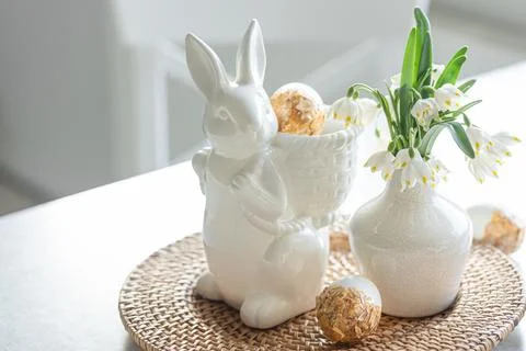 Easter still life with a ceramic hare, eggs and flowers. Stock Photos