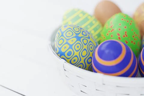 Easter still life. Colorful Easter eggs in a white basket on a wooden table.  Stock Illustration