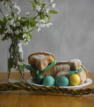 Easter still life containing two lamb cakes, four painted eggs, an Easter whip Stock Photos