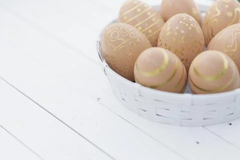 Easter still life. Easter eggs in brown color with a golden pattern in a whit Stock Illustration