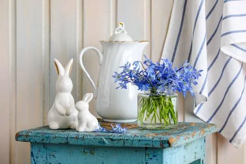 Easter still life with spring blue flowers and Bunny rabbit figurines on an.. Stock Photos