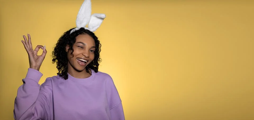 Easter studio shot with cute young woman in easter bunny ears showing ok sign Foto stock